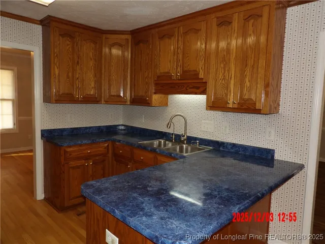a kitchen with a sink a microwave and cabinets