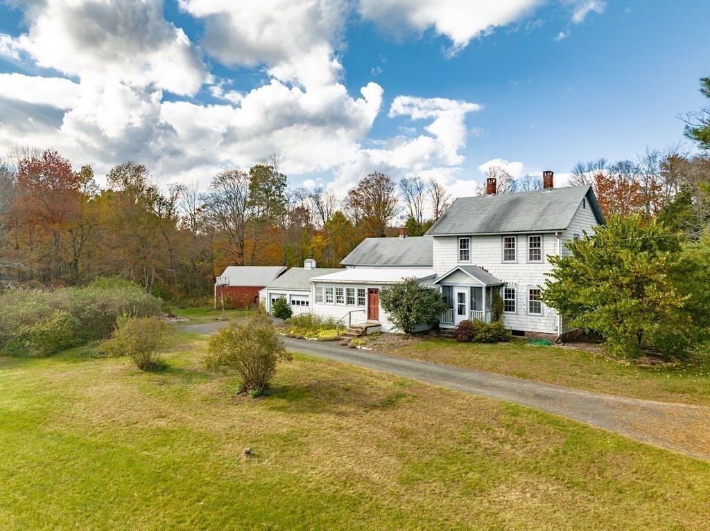 65 Old Bay Road Belchertown, MA 01007 - Photo 31 of 42 a view of a white house with table and chairs under an umbrella