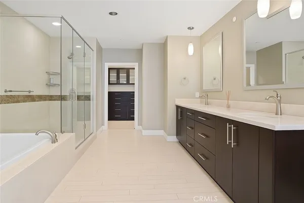 a spacious bathroom with a double vanity sink a large mirror and shower