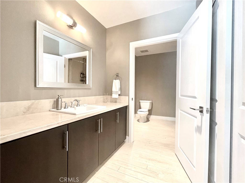 402 Rockefeller, Unit 118 Irvine, CA 92612 - Photo 17 of 24 a en suite bathroom with a granite countertop sink and mirror