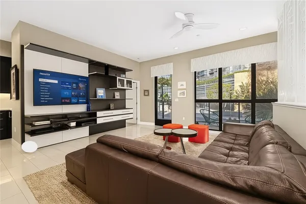 a living room with furniture flat screen tv and large window