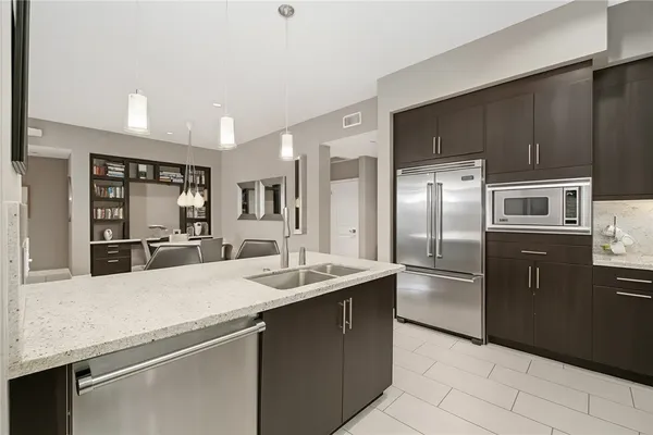 a kitchen with stainless steel appliances granite countertop a refrigerator and a sink