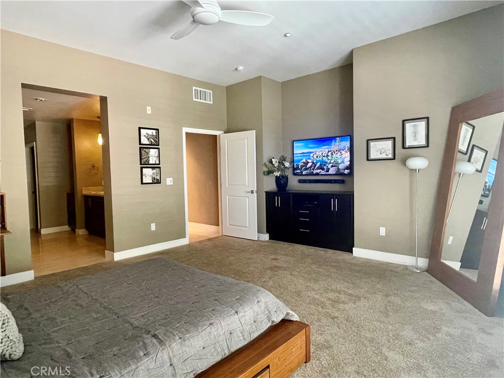 402 Rockefeller, Unit 118 Irvine, CA 92612 - Photo 9 of 24 a spacious bedroom with a bed and a walk in closet