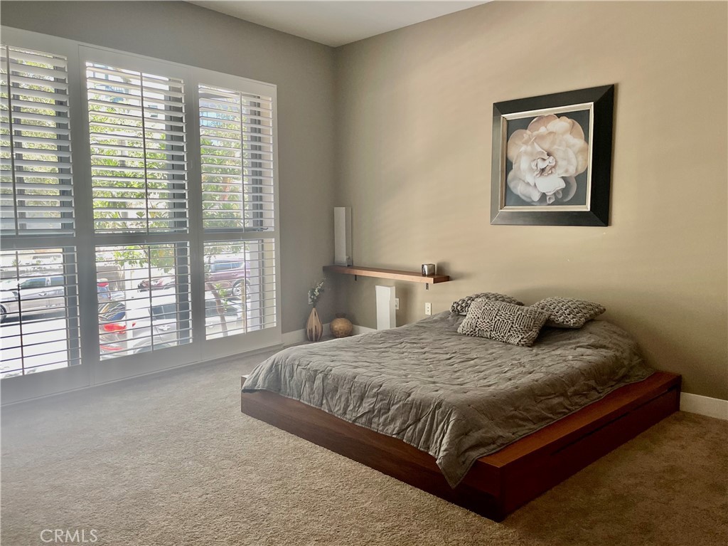 402 Rockefeller, Unit 118 Irvine, CA 92612 - Photo 10 of 24 a bedroom with a large bed and a large window