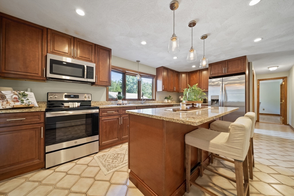 21 Cranberry Road Pepperell, MA 01463 - Photo 5 of 41 a kitchen with stainless steel appliances granite countertop a stove a sink and a microwave