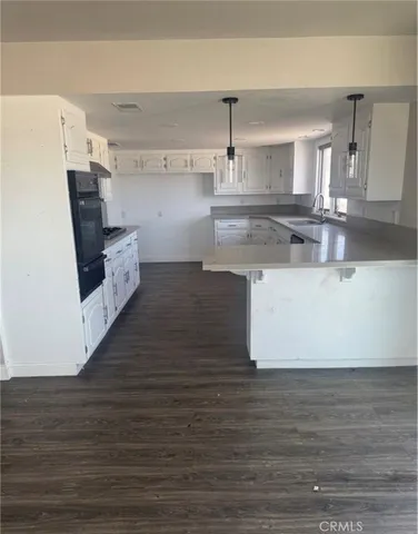 a large kitchen with cabinets and wooden floor
