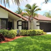 a front view of a house with a garden and plants