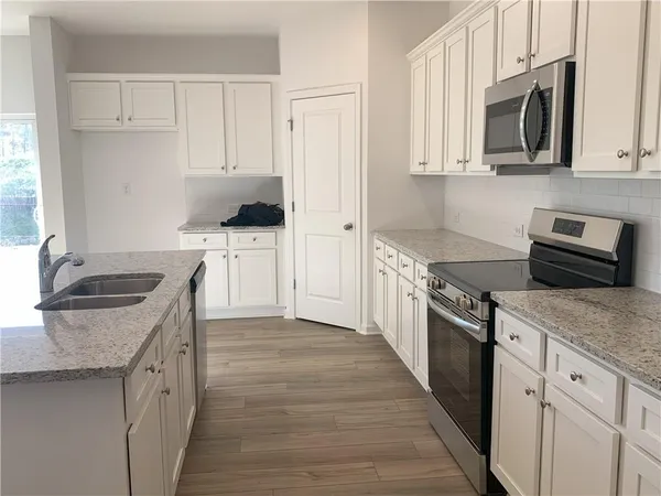 a kitchen with stainless steel appliances granite countertop a sink stove and microwave
