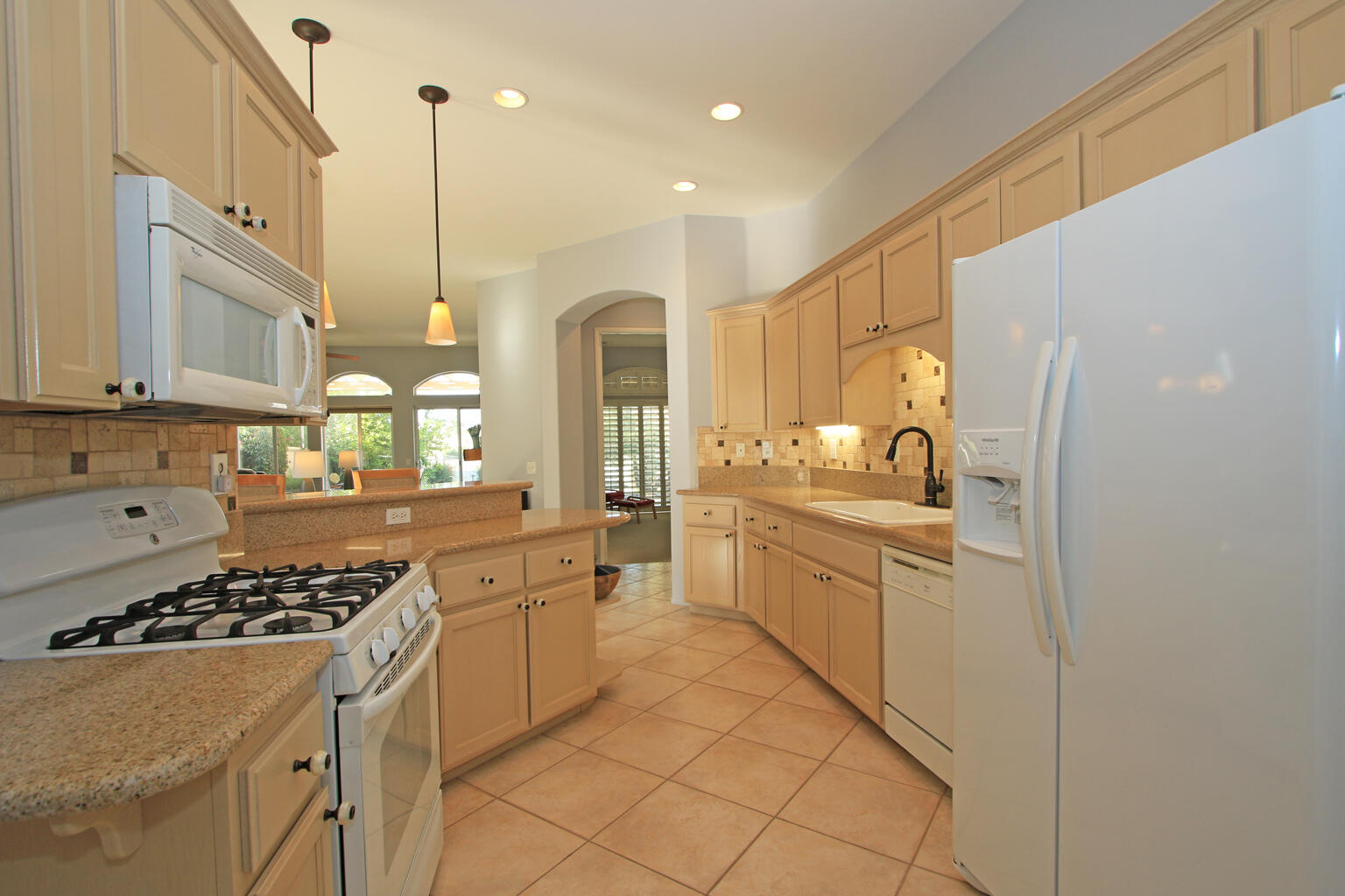 82652 Sky View Lane Indio, CA 92201 - Photo 12 of 44 a kitchen with stainless steel appliances a stove a sink cabinets and a refrigerator