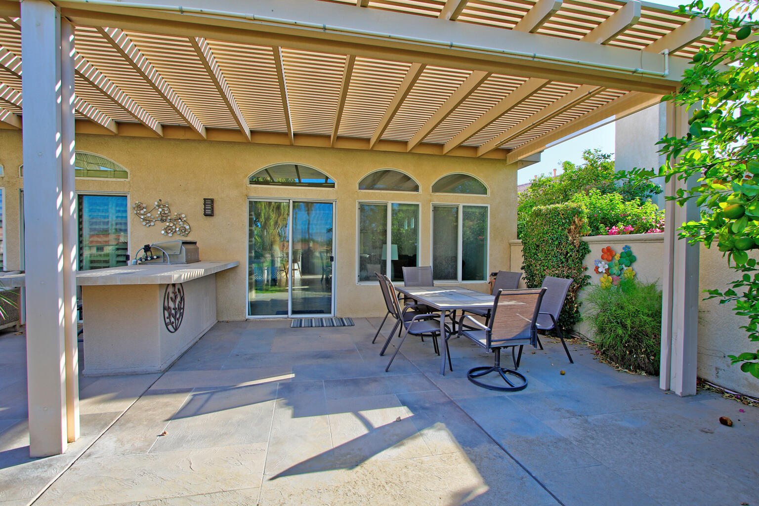 82652 Sky View Lane Indio, CA 92201 - Photo 38 of 44 a view of a patio with table and chairs potted plants and floor to ceiling window