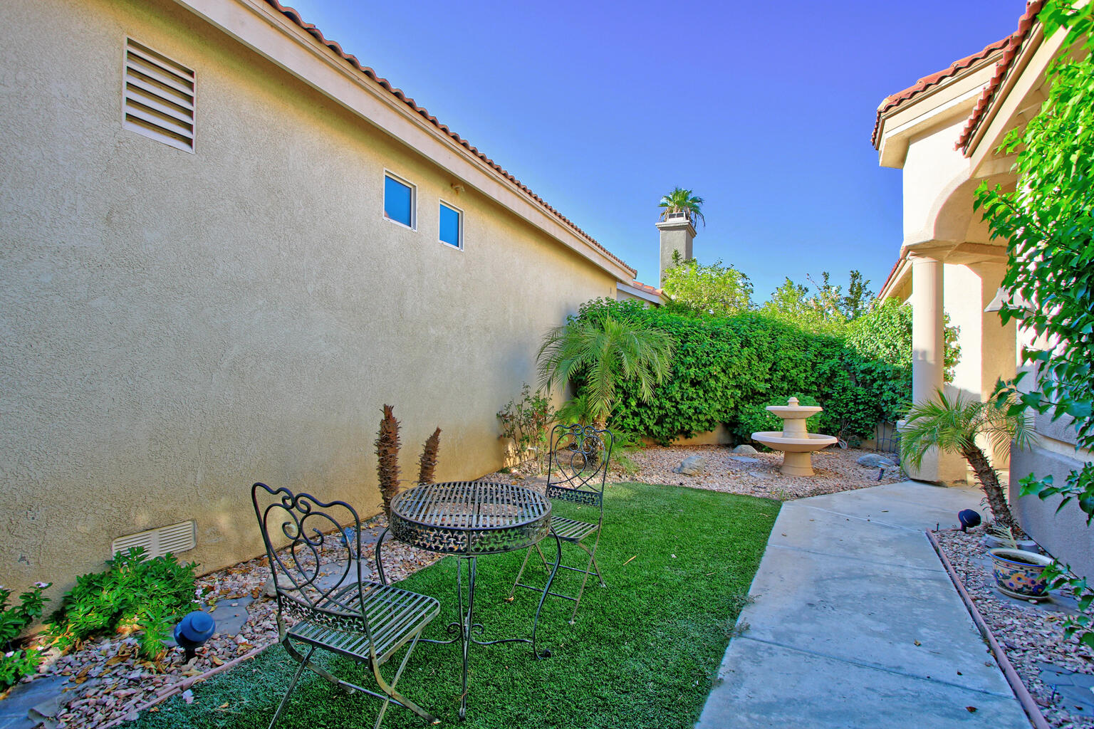 82652 Sky View Lane Indio, CA 92201 - Photo 7 of 44 a backyard of a house with table and chairs plants