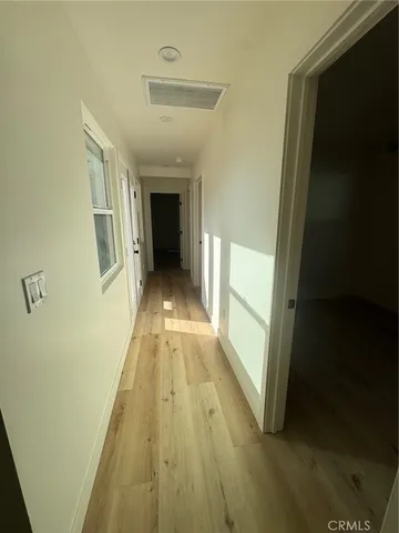 a view of a hallway with wooden floor and staircase