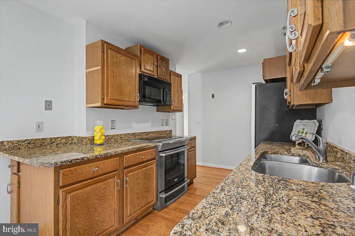 5 Steeplechase Road Wilmington, DE 19808 - Photo 16 of 39 a kitchen with stainless steel appliances granite countertop a sink stove and refrigerator