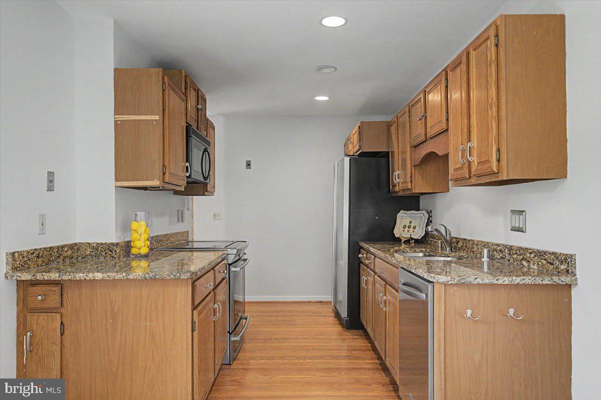 5 Steeplechase Road Wilmington, DE 19808 - Photo 17 of 39 a kitchen with stainless steel appliances granite countertop a sink stove refrigerator and cabinets