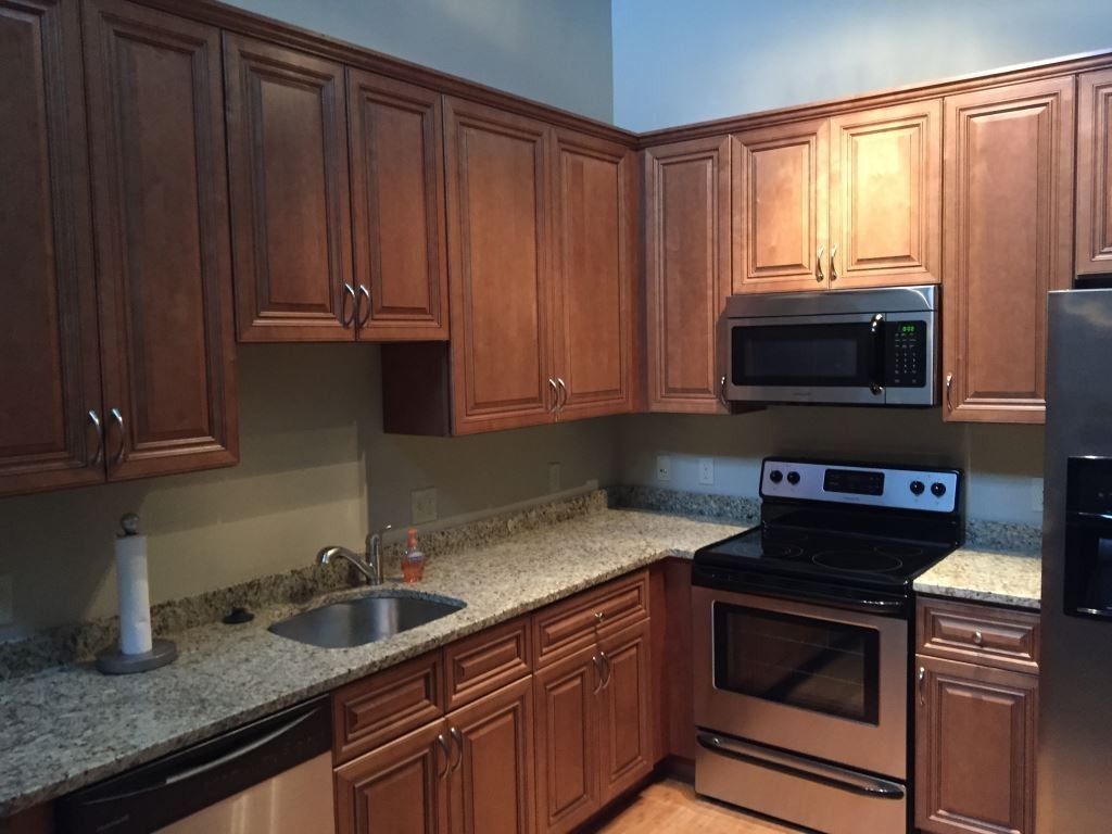 a kitchen with granite countertop a stove microwave and sink