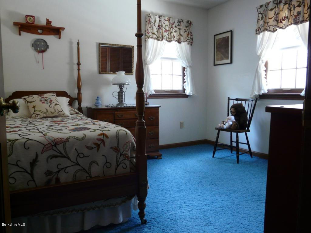 151 Old Post Road Richmond, MA 01201 - Photo 26 of 39 a bedroom with a bed and a chandelier