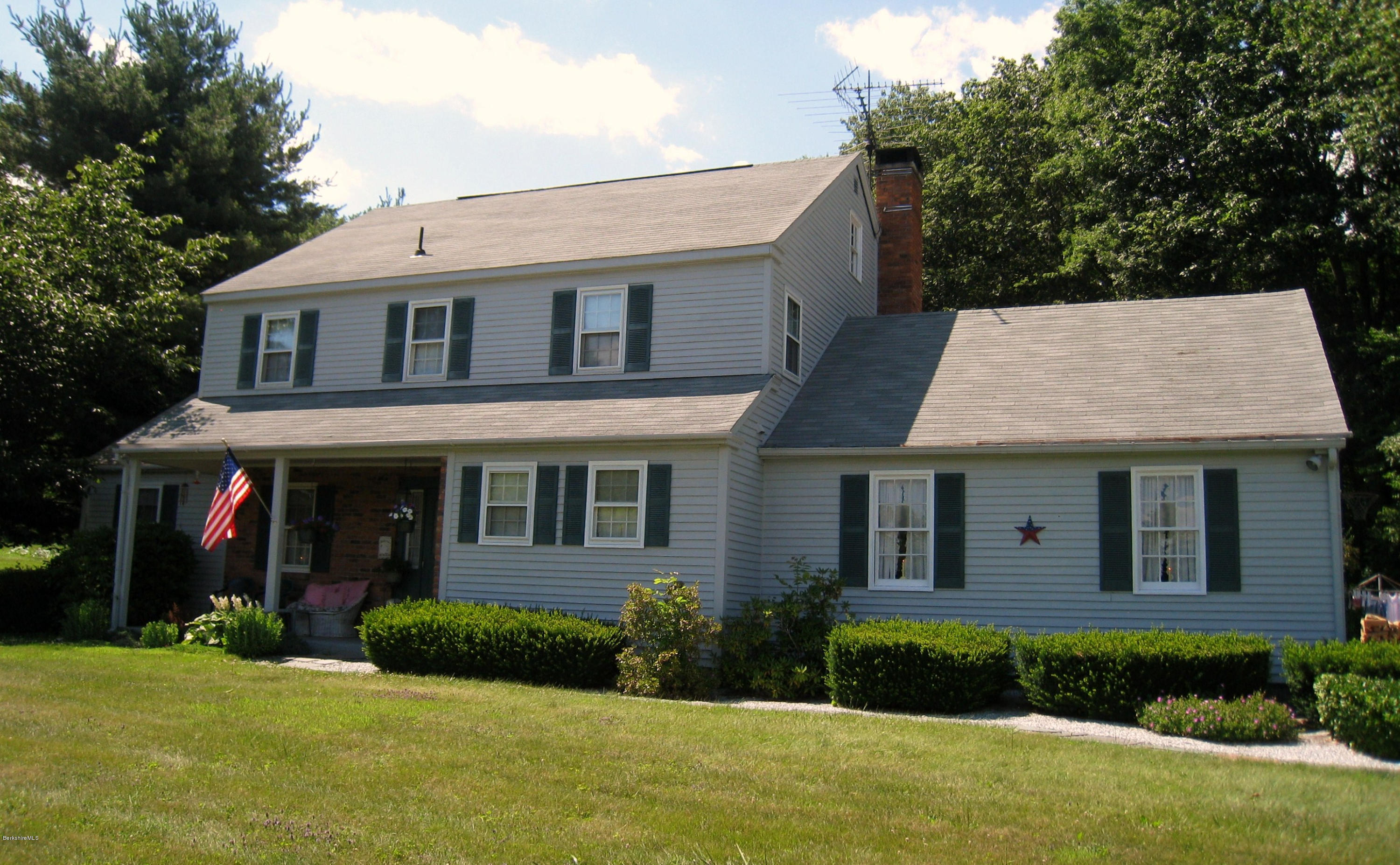 151 Old Post Road Richmond, MA 01201 - Photo 36 of 39 a view of a white house with large windows and a yard with plants and large tree