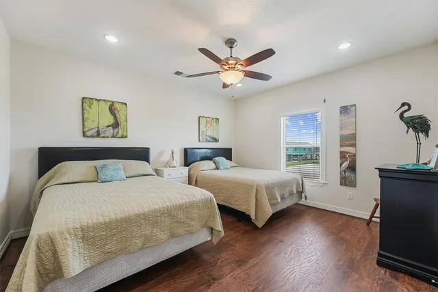 a bedroom with a large bed window and a ceiling fan