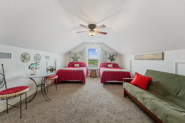 a spacious bedroom with two beds and a window