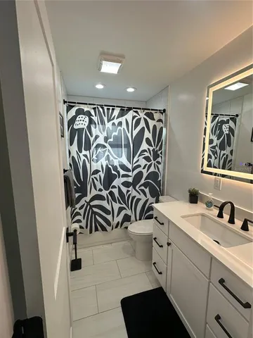 a bathroom with a sink and mirror with toilet