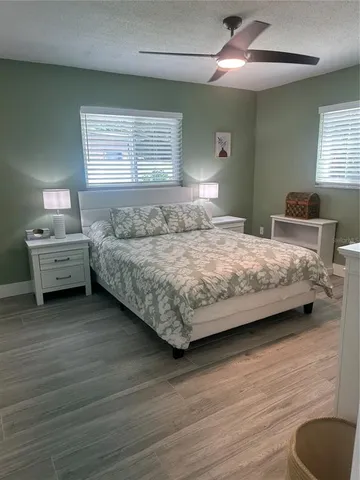a bedroom with a bed and a dresser next to a window