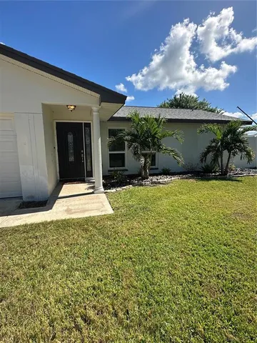 a view of a house with backyard and sitting area