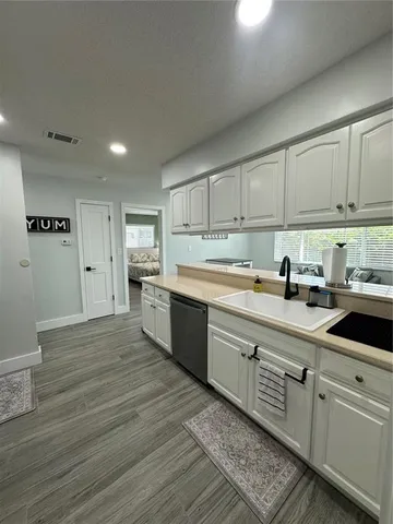 a kitchen with cabinets oven and a dishwasher with wooden floor