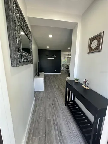 a view of a hallway with wooden floor and staircase