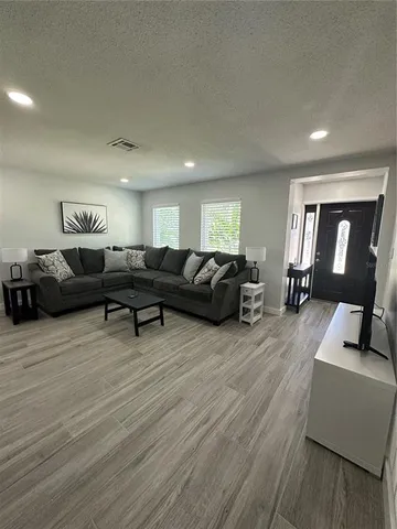 a living room with furniture and a wooden floor