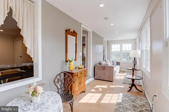 a view of a hallway with wooden floor and a bathroom