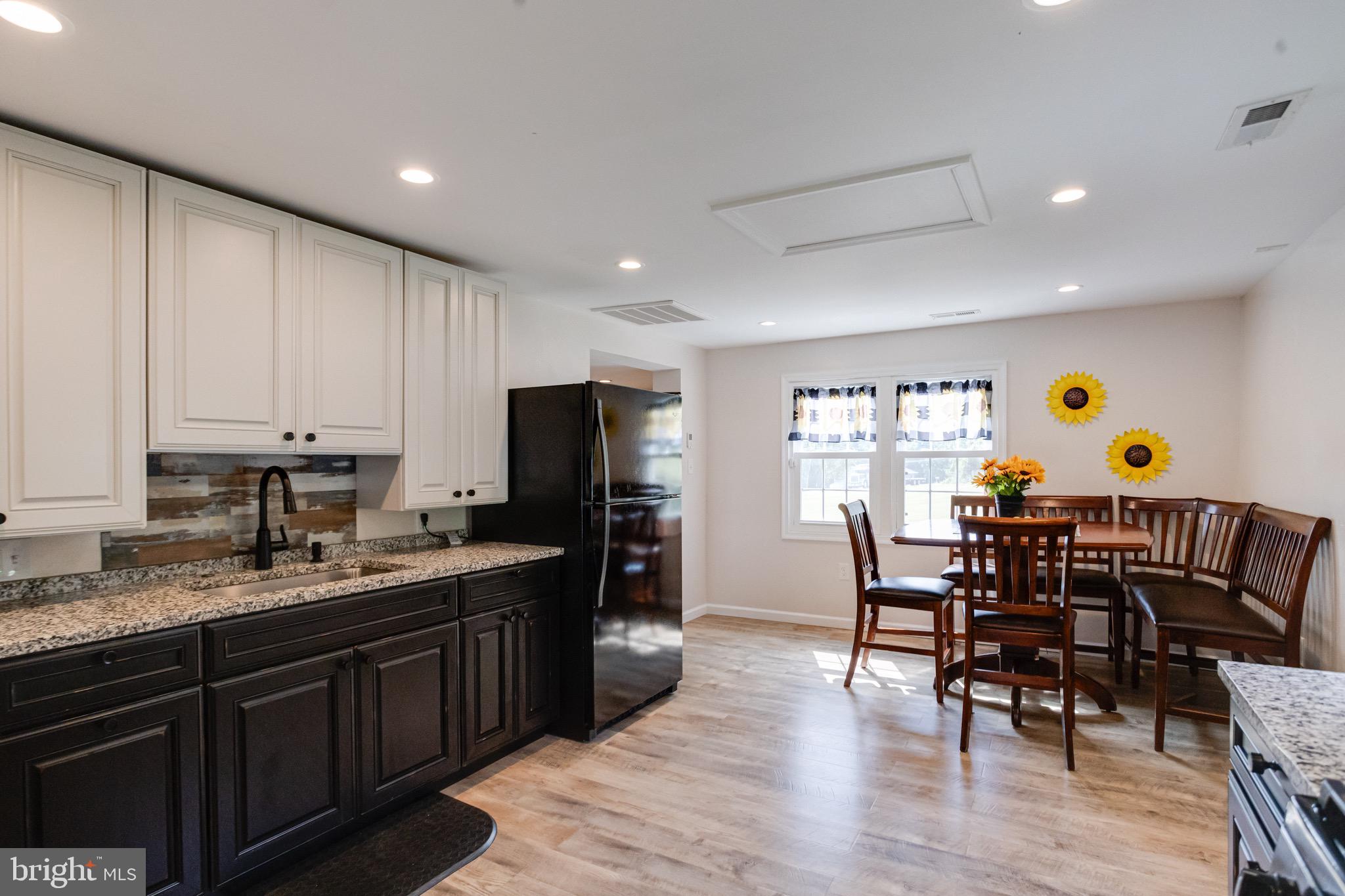 203 Blythedale Road Perryville, MD 21903 - Photo 46 of 104 a kitchen with stainless steel appliances granite countertop a dining table chairs refrigerator and microwave