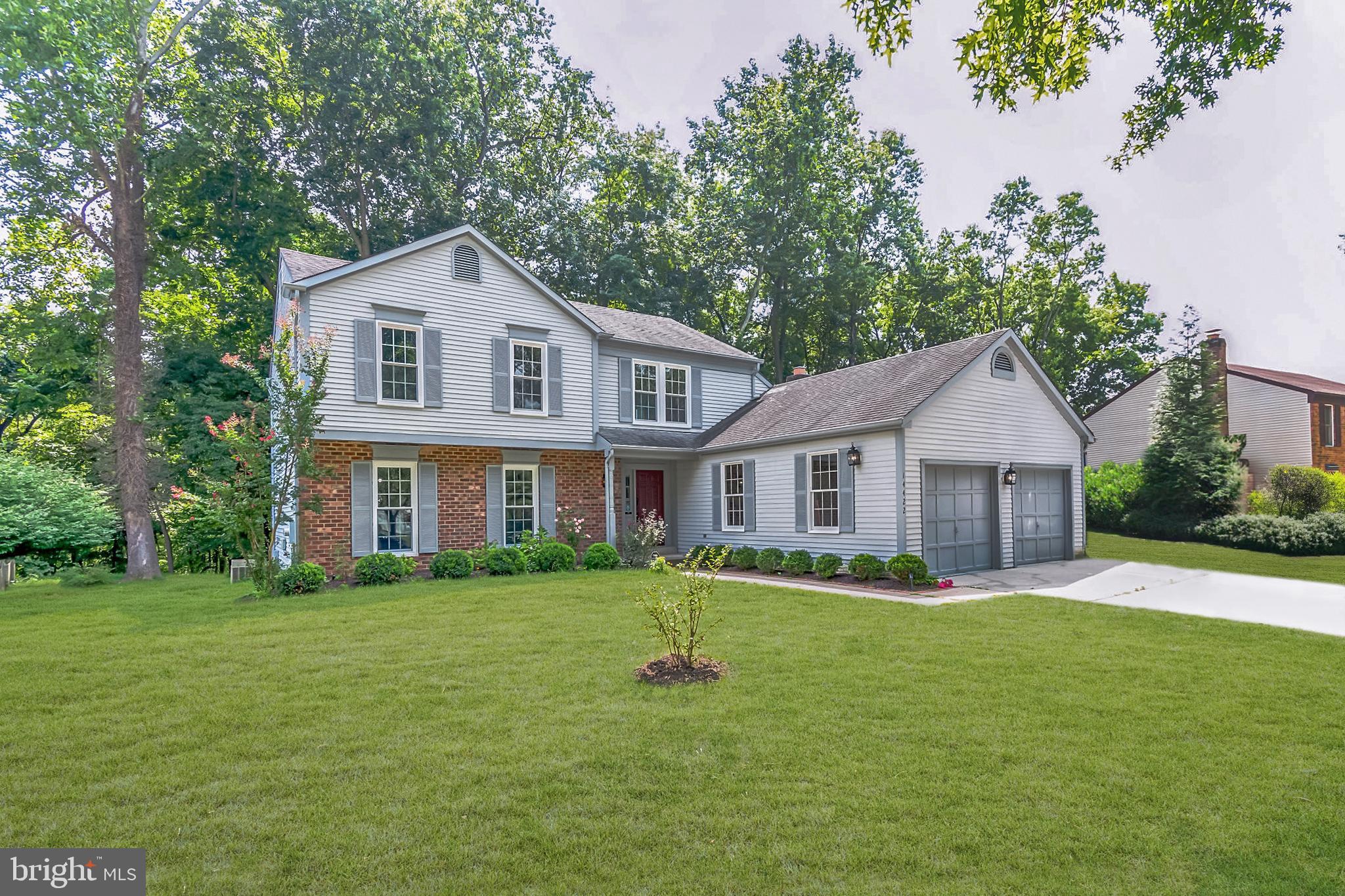 14422 Pebblestone Drive Silver Spring, MD 20905 - Photo 1 of 37 a front view of a house with a garden and trees