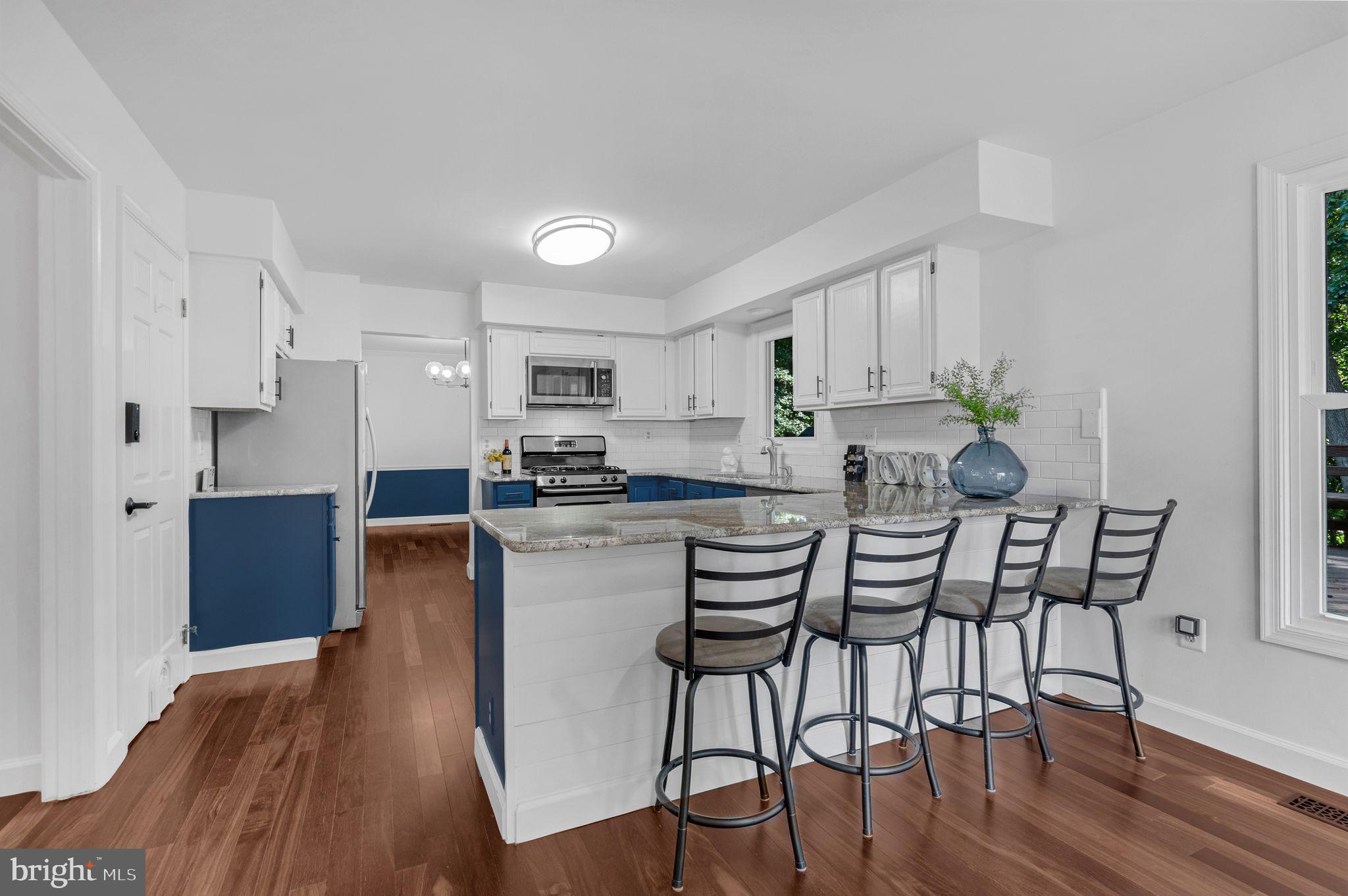 14422 Pebblestone Drive Silver Spring, MD 20905 - Photo 2 of 37 a kitchen with stainless steel appliances a dining table chairs and wooden floor