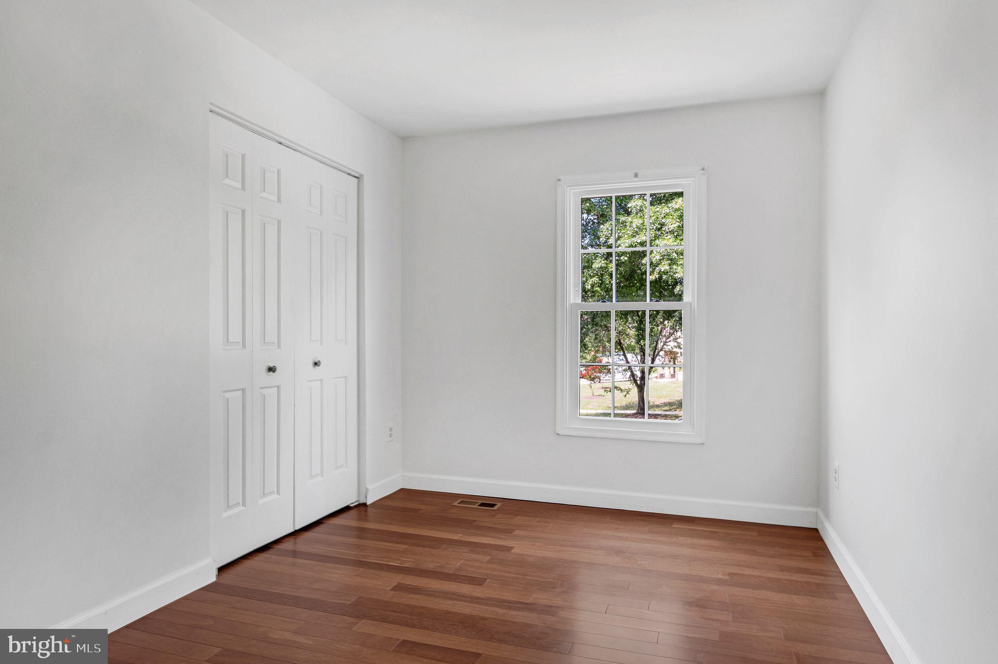 14422 Pebblestone Drive Silver Spring, MD 20905 - Photo 27 of 37 an empty room with wooden floor and windows