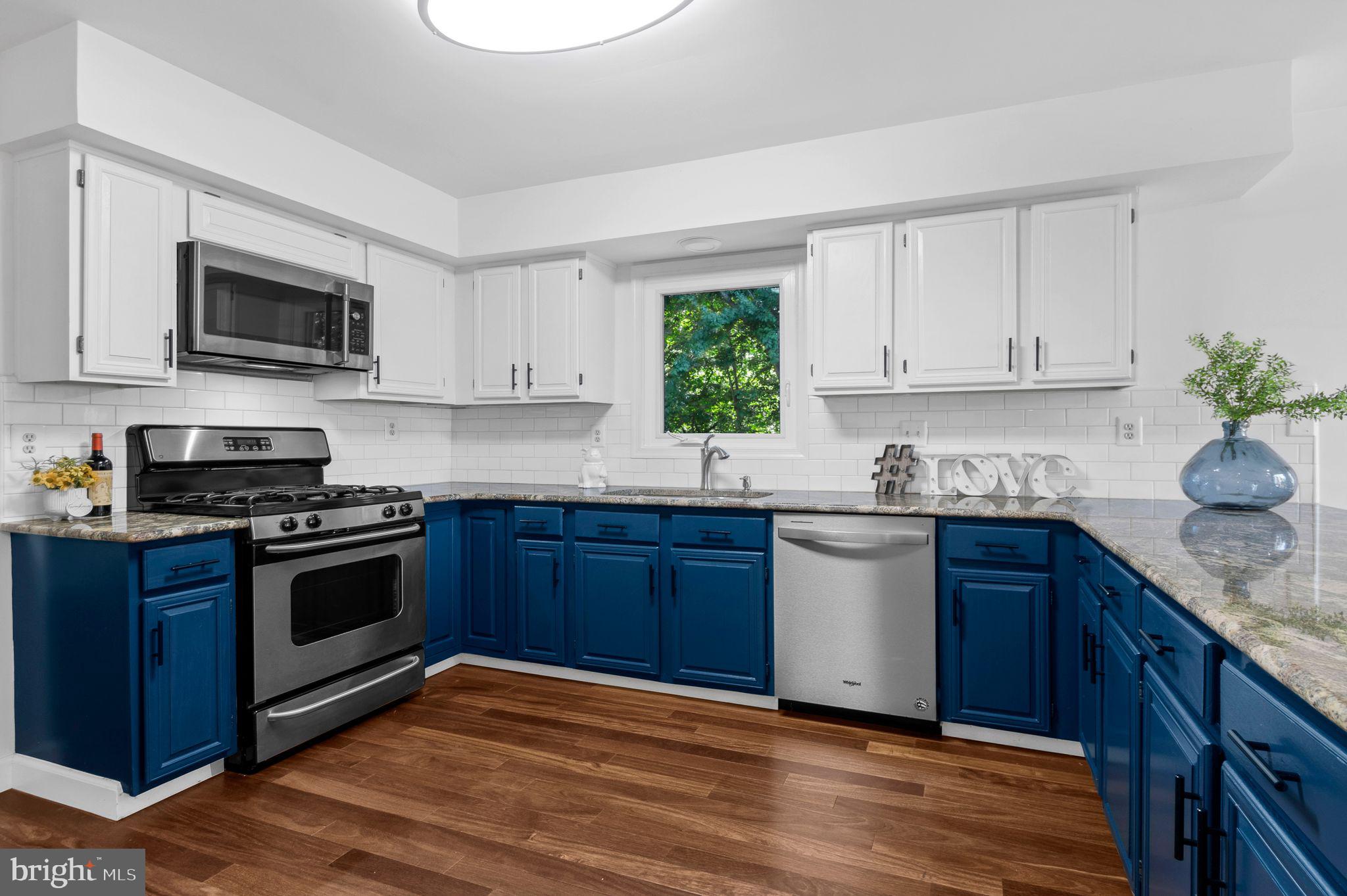 14422 Pebblestone Drive Silver Spring, MD 20905 - Photo 4 of 37 a kitchen with stainless steel appliances granite countertop a sink a stove a microwave and cabinets