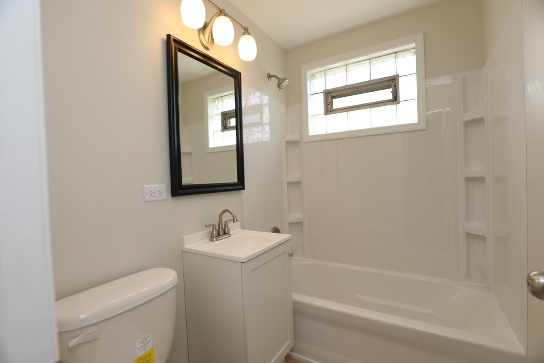 2207 175th Street Homewood, IL 60430 - Photo 4 of 13 a bathroom with a toilet sink and mirror