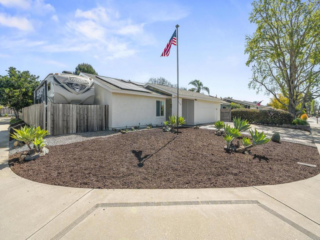 a front view of a house with a yard and potted plants