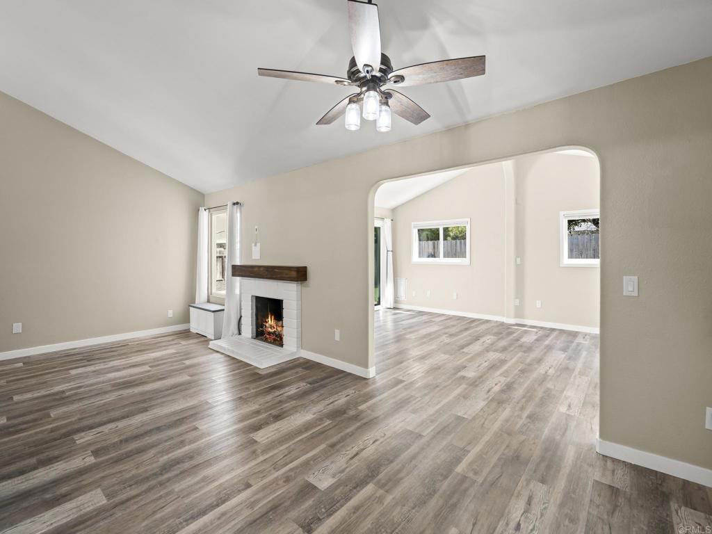 726 Fredricks Avenue Oceanside, CA 92058 - Photo 13 of 38 an empty room with wooden floor fireplace and windows