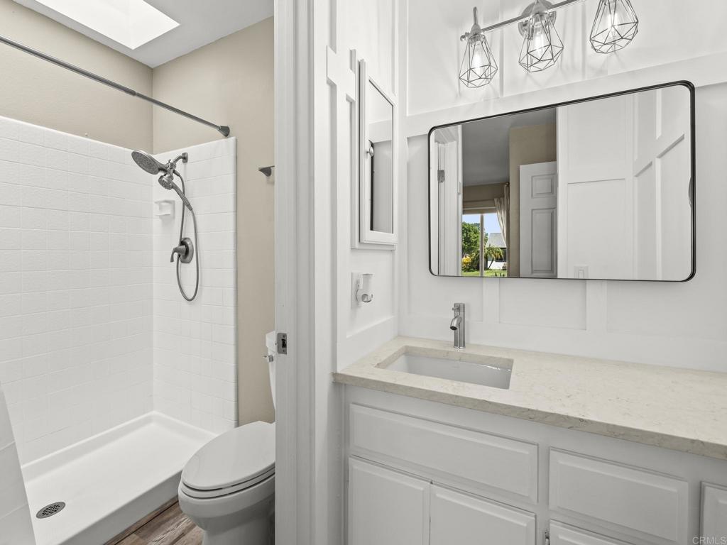 726 Fredricks Avenue Oceanside, CA 92058 - Photo 21 of 38 a bathroom with a granite countertop sink a toilet a shower and a mirror