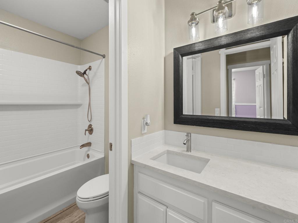 726 Fredricks Avenue Oceanside, CA 92058 - Photo 28 of 38 a bathroom with a granite countertop sink a toilet and a bathtub