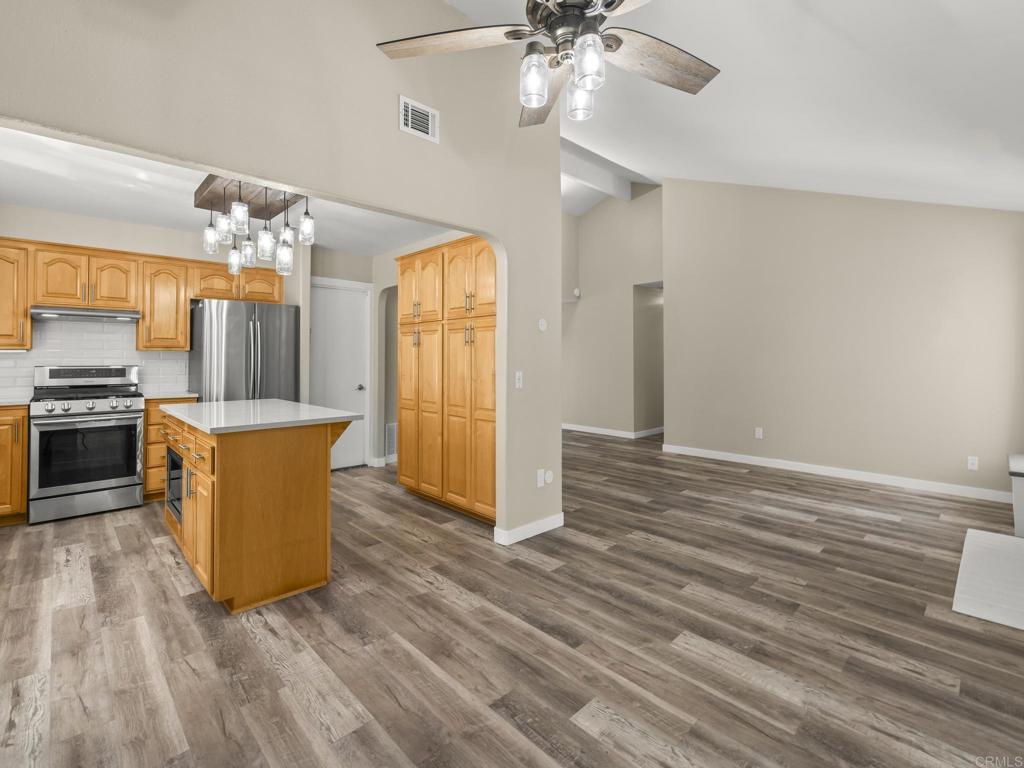 726 Fredricks Avenue Oceanside, CA 92058 - Photo 7 of 38 a room with kitchen island stainless steel appliances furniture a chandelier and wooden floor