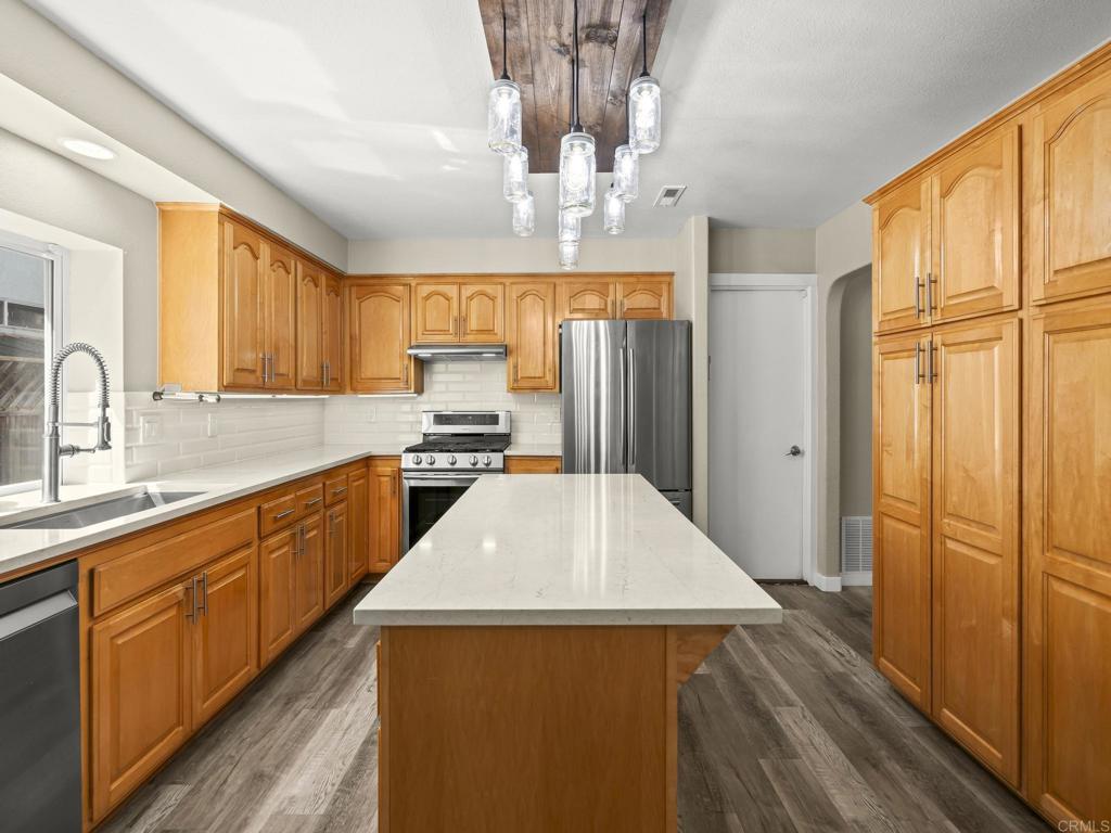 726 Fredricks Avenue Oceanside, CA 92058 - Photo 9 of 38 a kitchen with stainless steel appliances a refrigerator and wooden cabinets