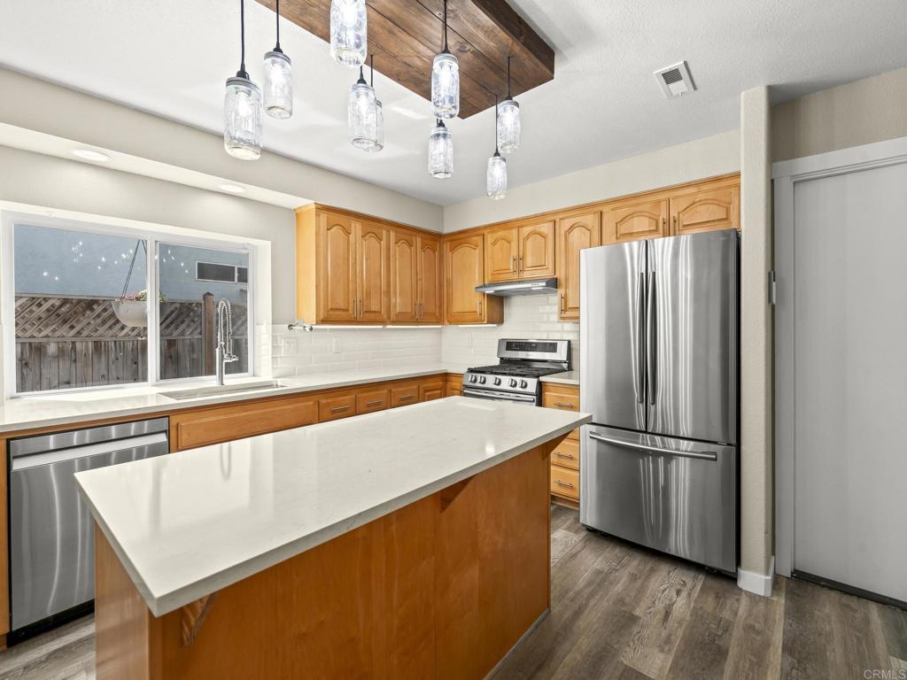726 Fredricks Avenue Oceanside, CA 92058 - Photo 10 of 38 a kitchen with stainless steel appliances granite countertop a refrigerator a sink dishwasher a stove and a refrigerator with wooden floor