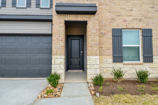a front view of a house with a yard and flowers