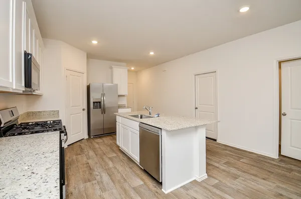 a kitchen with granite countertop a sink and a stove top oven