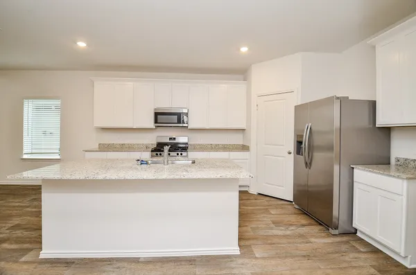 a kitchen with stainless steel appliances granite countertop a sink stove microwave and refrigerator