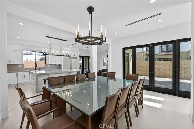 a dining room with furniture a chandelier and wooden floor