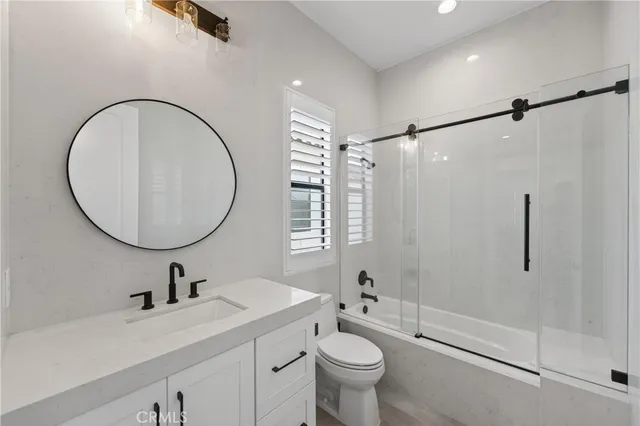 a bathroom with a sink toilet a mirror and shower
