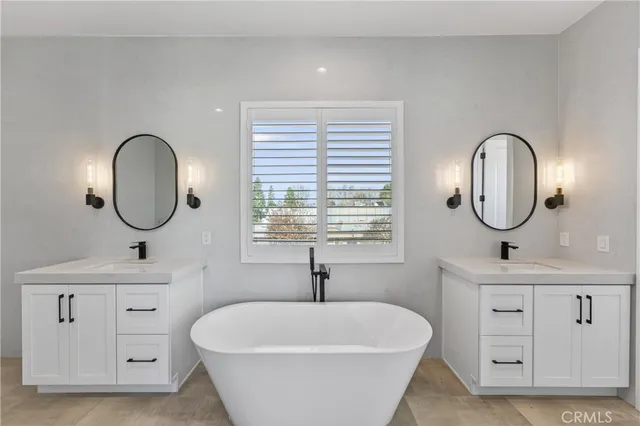 a spacious bathroom with a double vanity sink double mirror and window