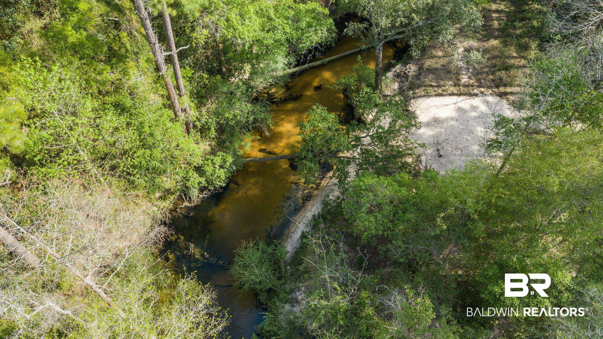 22800 River Road South Daphne, AL 36526 - Photo 7 of 52 Bird's eye view of a nearby body of water and a tree filled landscape